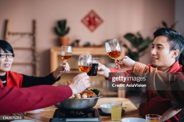 close up of three generations of joyful asian family celebrating chinese new year and toasting while enjoying scrumptious traditional chinese poon choi on reunion dinner - shared prosperity stock pictures, royalty-free photos & images