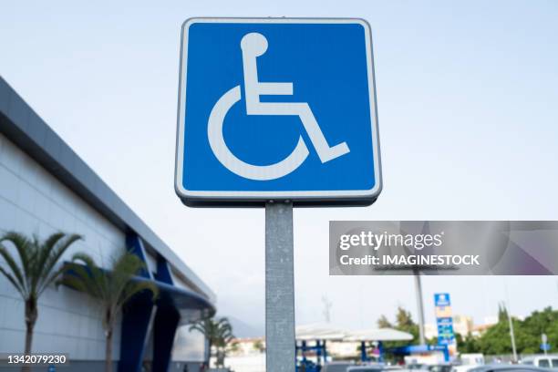 disabled parking sign located in a shopping mall - señal de circulación fotografías e imágenes de stock