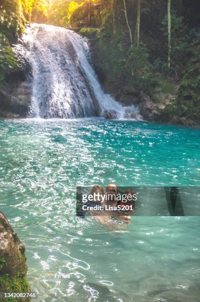 family swimming in secluded natural waterfall lagoon in tropical paradise - lagoon forest stock pictures, royalty-free photos & images