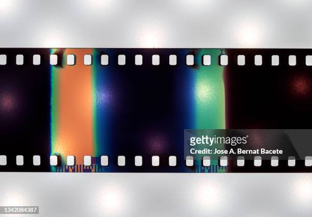 color negative 35mm film stripes on a white background. - industria cinematográfica fotografías e imágenes de stock