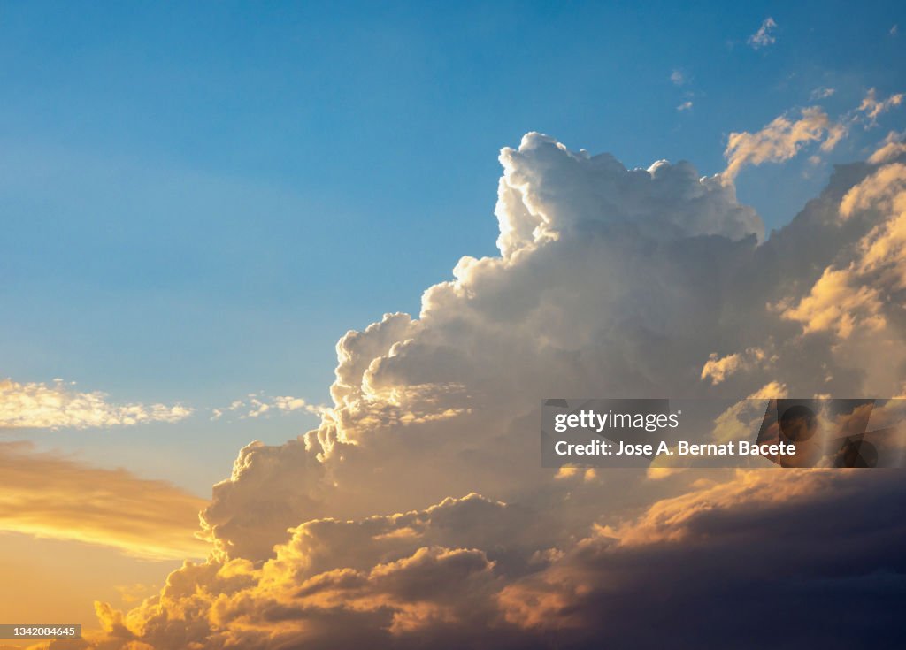 Developing storm cloud over the sky at sunset.