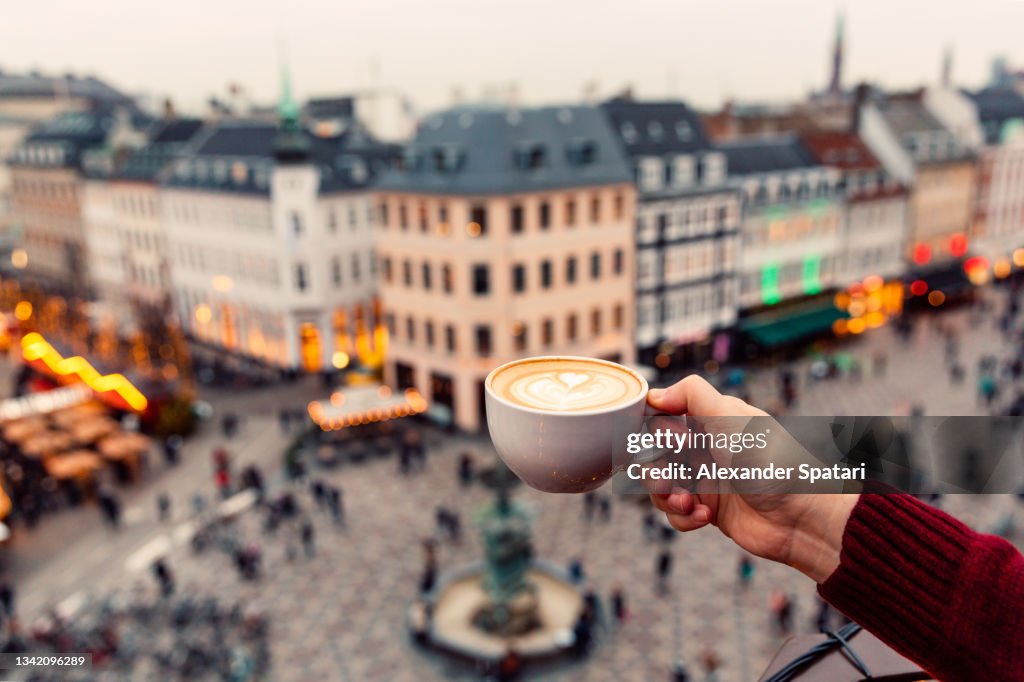 Man drinking coffee with a view of Copenhagen skyline, Denmark