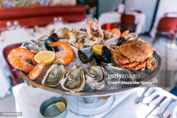 seafood platter with oysters, prawns and crab in a restaurant - vis en zeevruchten stockfoto's en -beelden