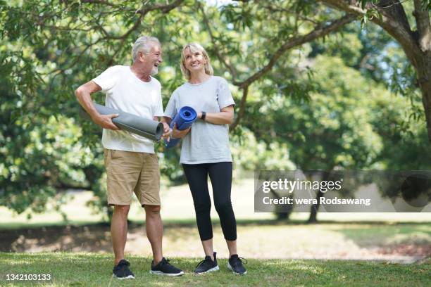 senior couples self-caring prepare yoga exercise at park - young at heart stock-fotos und bilder