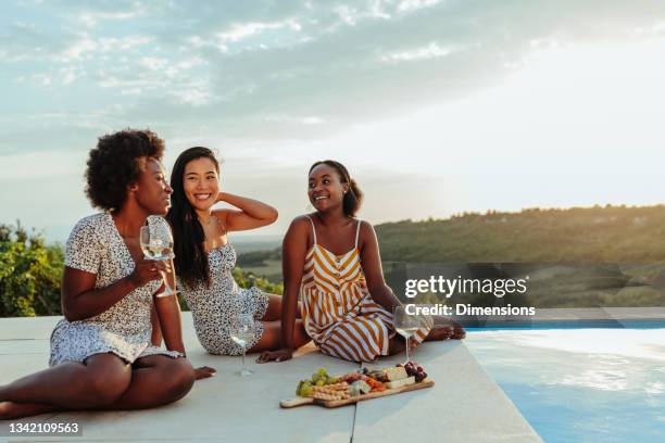 smiling multiracial female best friends at picnic - black woman picnic stock pictures, royalty-free photos & images