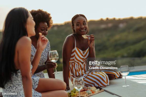 Smiling multiracial female best friends at picnic