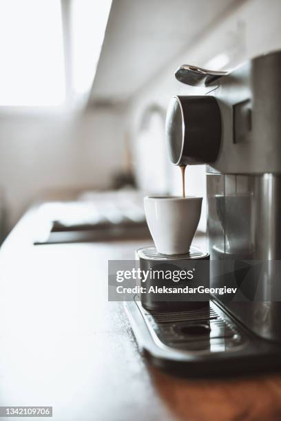 espresso machine pouring hot coffee in cup during morning - coffee machine home stock pictures, royalty-free photos & images