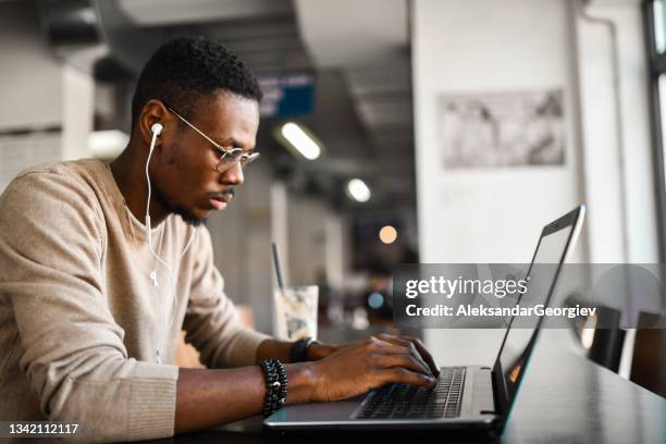 african male studying on laptop while enjoying music and coffee - the soundtrack of my life stock pictures, royalty-free photos & images