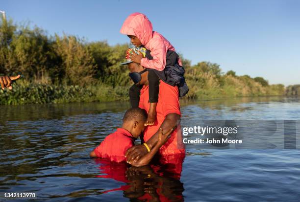 Haitian father carries his children across the Rio Grande into Del Rio, Texas on September 23 from Ciudad Acuna, Mexico. Mexican immigration...