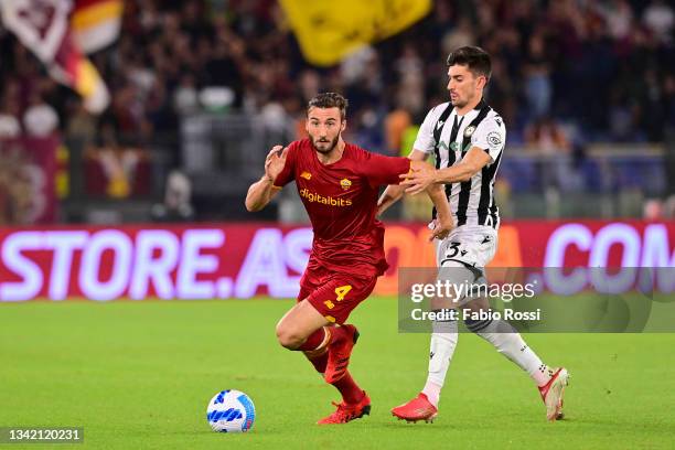 Bryan Cristante of AS Roma is challenged by Ignacio Pussetto during the Serie A match between AS Roma v Udinese Calcio at Stadio Olimpico on...