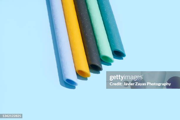 collection of ecological reusable colorful silicone straws on blue background - silicone 個照片及圖片檔