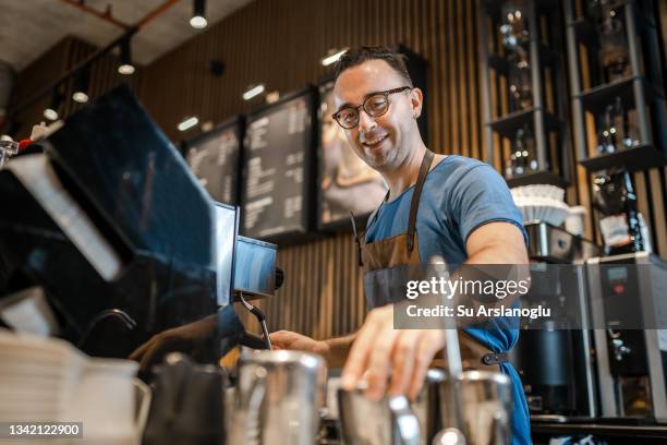 male barista making coffee for customers at the bar - steam machine stock pictures, royalty-free photos & images