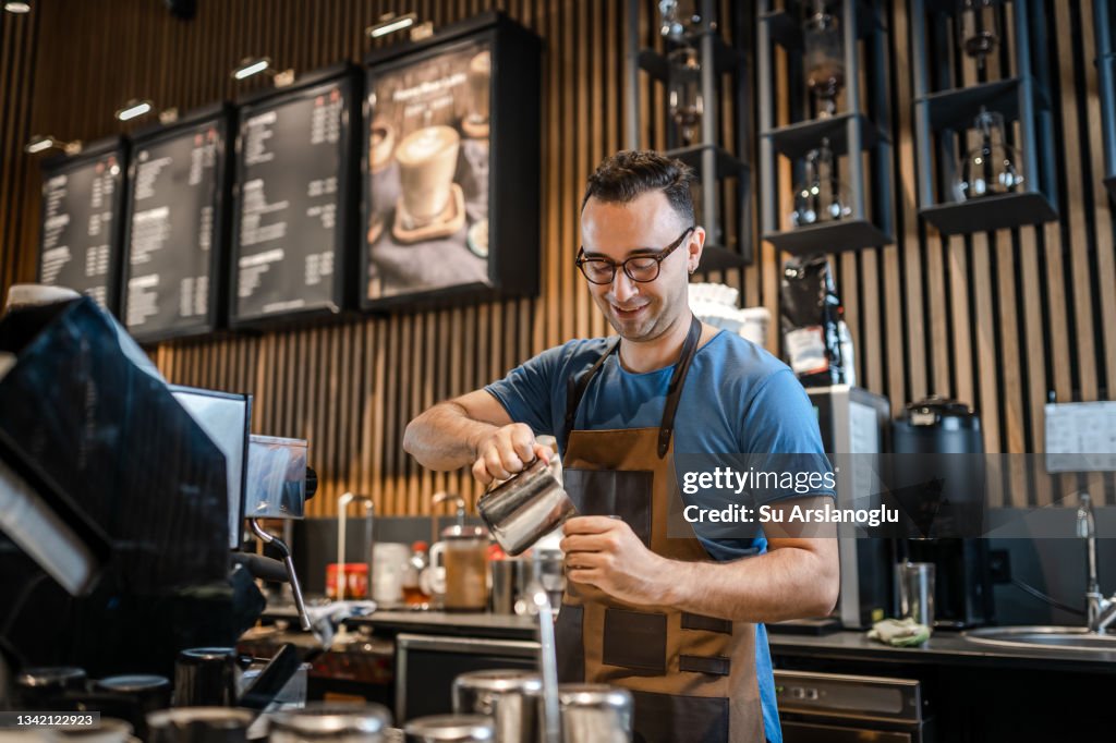 Männlicher Barista macht Kaffee für Kunden an der Bar