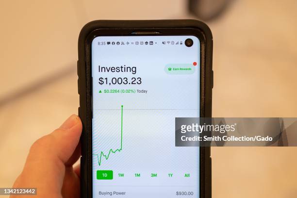 Close-up of person's hand holding a smartphone with the interface of the Robinhood investment app visible, Lafayette, California, September 15, 2021.