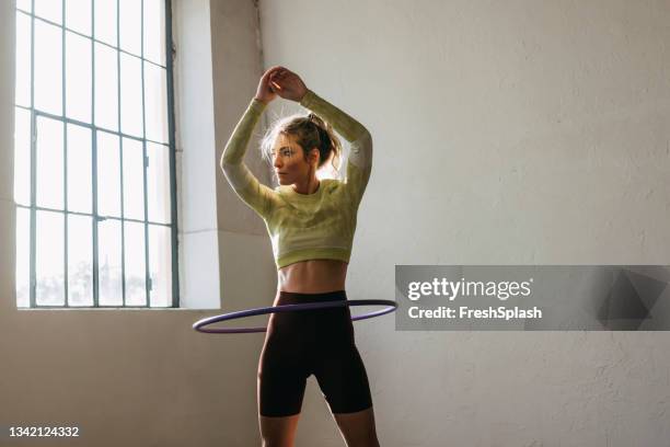 fitness frau wirbelt hula hoop - gymnastikreifen stock-fotos und bilder