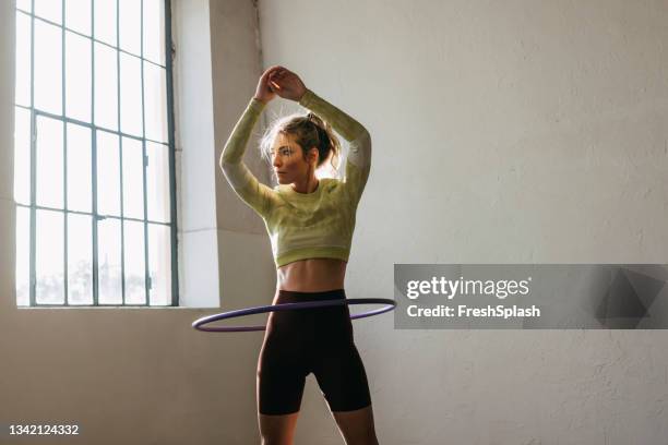 fitness woman twirling hula hoop - plastic hoop stock pictures, royalty-free photos & images