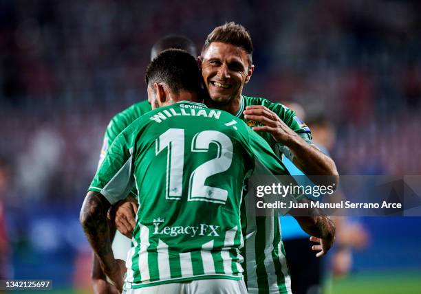 Willian Jose Da Silva of Real Betis Balompie celebrates with his teammates Joaquin Sanchez of Real Betis Balompie after scoring his team's third goal...