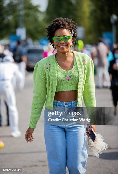 A guest is seen wearing cardigan, cropped top, denim jeans News  Photo Getty Images