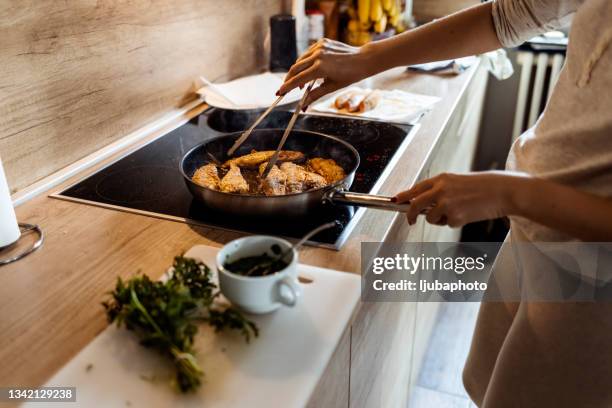 frau bereitet gesundes mittagessen zu hause zu - fish fry stock-fotos und bilder