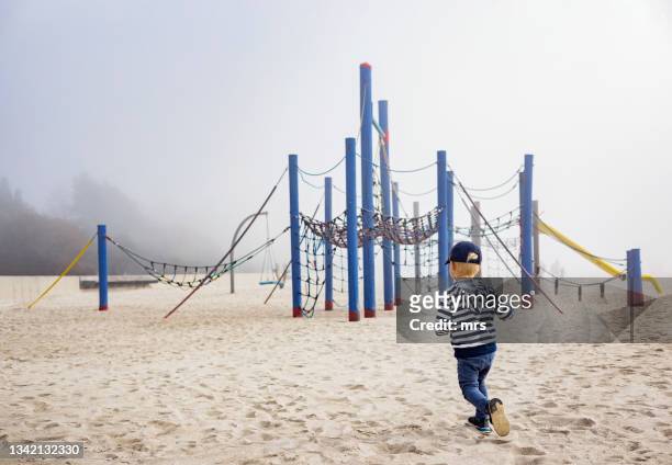 little boy at empty playground - playground stock-fotos und bilder