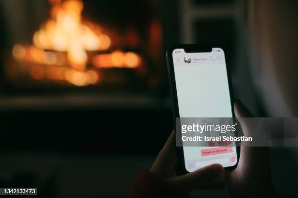 close up view of a little girl sending a message to santa claus with a mobile phone. - christmas smartphone stock-fotos und bilder