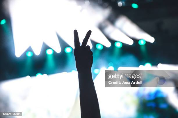 peace sign hand symbol at music concert venue - peace symbol stockfoto's en -beelden