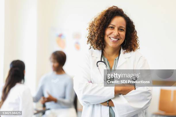 retrato de una doctora adulta mediana segura de sí misma - happy patient fotografías e imágenes de stock