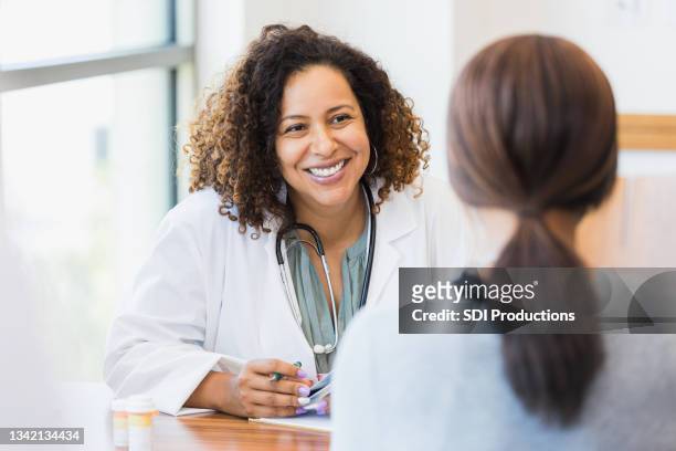 un médecin attentionné écoute le patient - mid adult women photos et images de collection
