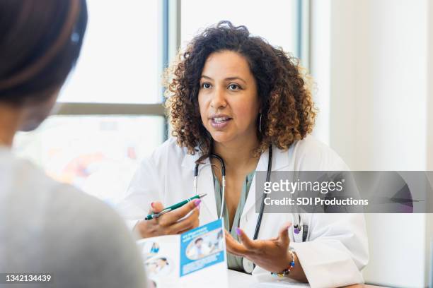 la doctora habla sobre la atención médica con el paciente - decisiones fotografías e imágenes de stock