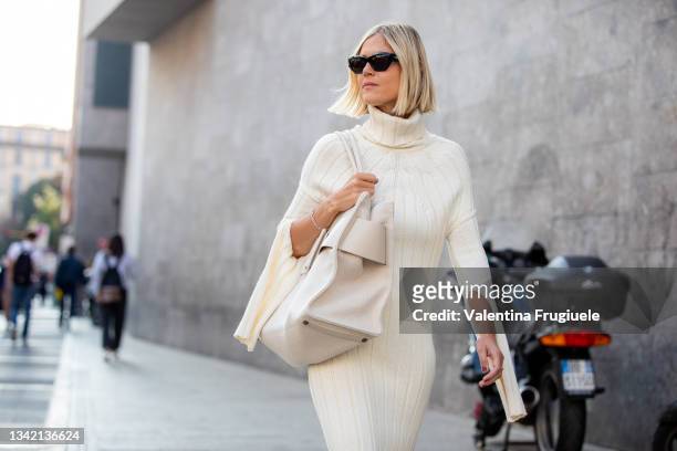 Linda Tol outside Max Mara fashion show wearing a knitted white dress, oversized white bag and sunglasses during the Milan Fashion Week - Spring /...