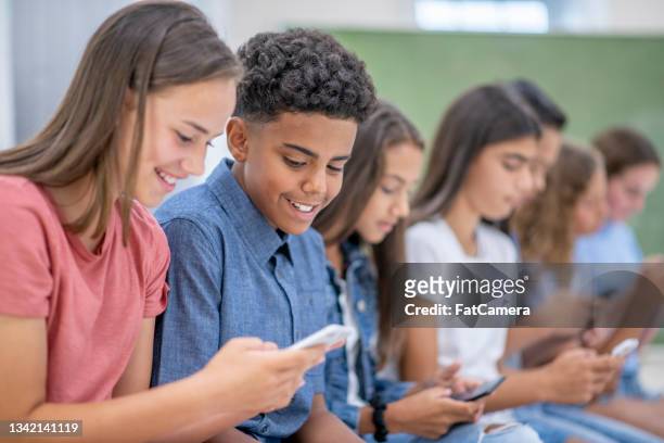 multi-ethnic high school students on their cell phones - ten to fifteen stock pictures, royalty-free photos & images