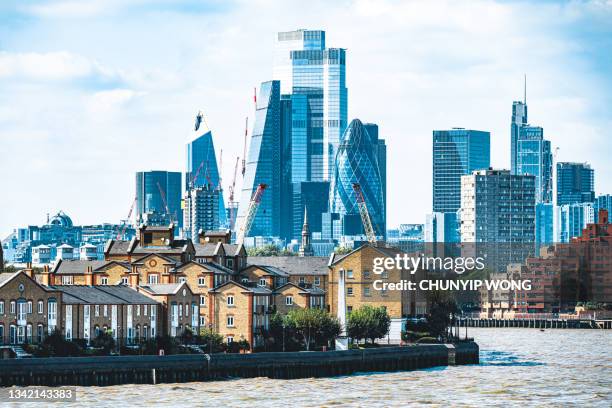 arranha-céus da cidade de londres com vista para casas ao longo do rio tâmisa - isle of dogs london - fotografias e filmes do acervo