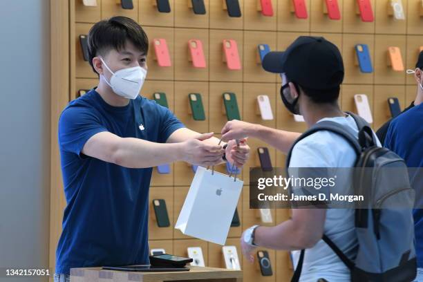 Customer receives their new products inside the Apple Store on George Street on September 24, 2021 in Sydney, Australia. The new Apple iPhone 13 and...