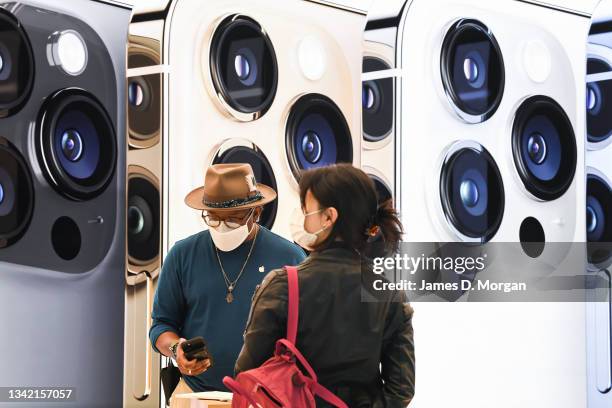 Customer waits to collect her new product inside the Apple Store on George Street on September 24, 2021 in Sydney, Australia. The new Apple iPhone 13...