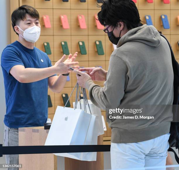 Jun Matsuda receiving his new Apple products from an Apple staff member inside the Apple Store on George Street on September 24, 2021 in Sydney,...