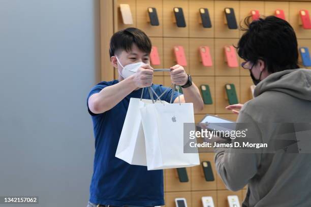 Jun Matsuda receiving his new Apple products from an Apple staff member inside the Apple Store on George Street on September 24, 2021 in Sydney,...