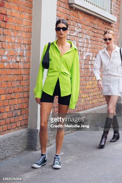 Model Mica Arganaraz wears a lime green button up top, black biker shorts, and black Converse sneakers after the Fendi show during the Milan Fashion...
