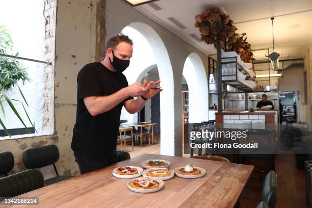 Head chef and general manager Hayden Phiskie photographs the pizza fritta takeaway options for social media at Ada Restaurant on September 24, 2021...