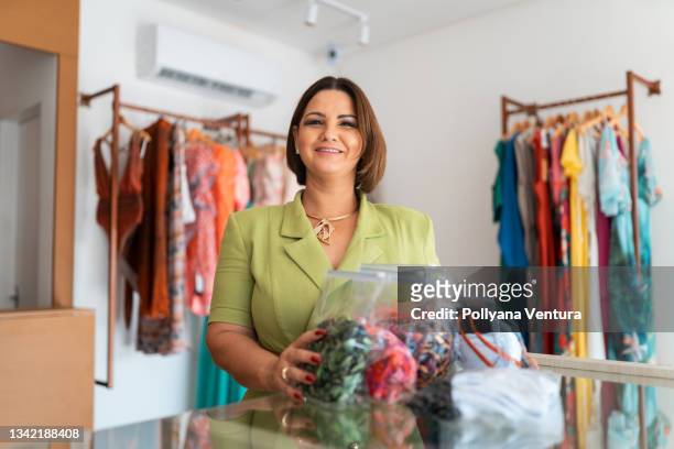 mujer vendiendo ropa - dependiente de tienda fotografías e imágenes de stock