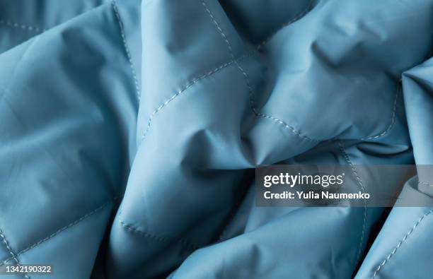 blue puffer jacket texture, close-up - winter plumage stock pictures, royalty-free photos & images