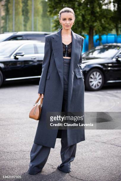 Nataly Osmann, wearing grey coat, grey pants, black crop top and brown bag, poses ahead of the Boss fashion show during the Milan Fashion Week -...