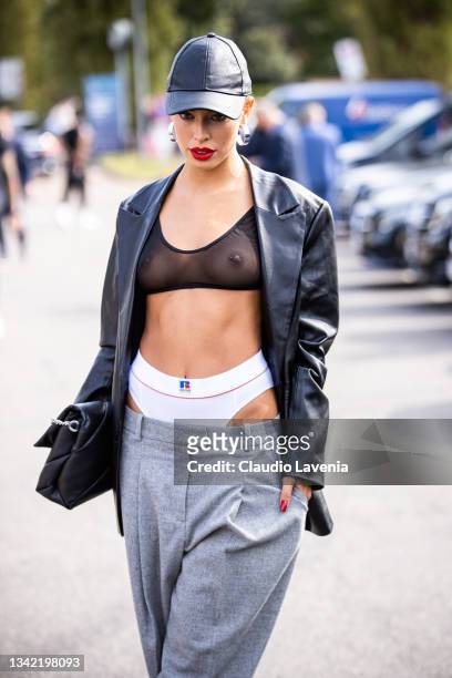 Jessica Goicoechea, wearing sheer top, underwear, cap, black jacket and grey pants, poses ahead of the Boss fashion show during the Milan Fashion...