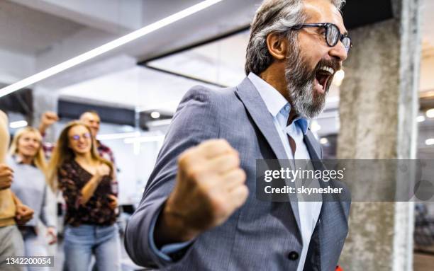 joyful businessman screaming during sports race with his colleagues in the office. - yes stockfoto's en -beelden