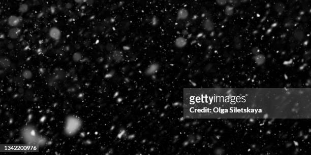 falling snow on black background - schnee stock-fotos und bilder