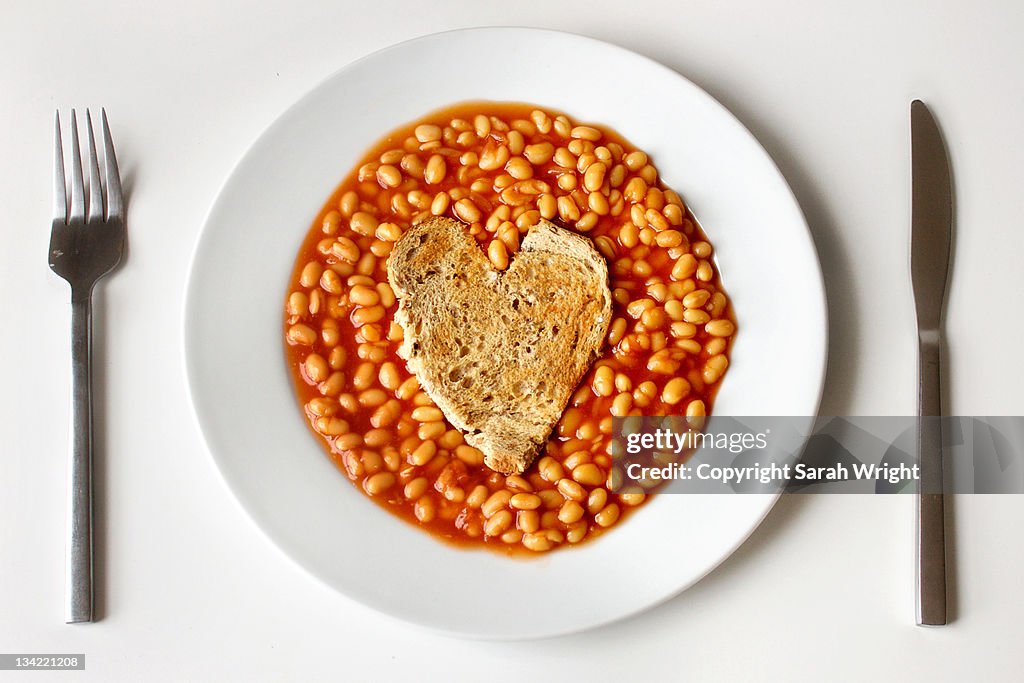 Beans served in plate with fork and knife