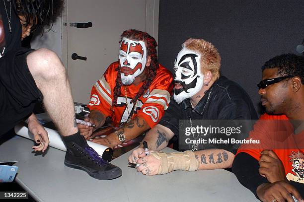 Musicians Shaggy 2 Dope, Violent J and Esham from the group "Insane Clown Posse" sign an autograph for a fan at the Los Angeles Comic Book and...