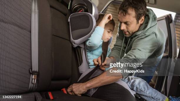 息子のシートベルトを締める男 - 庇護者 ストックフォトと画像