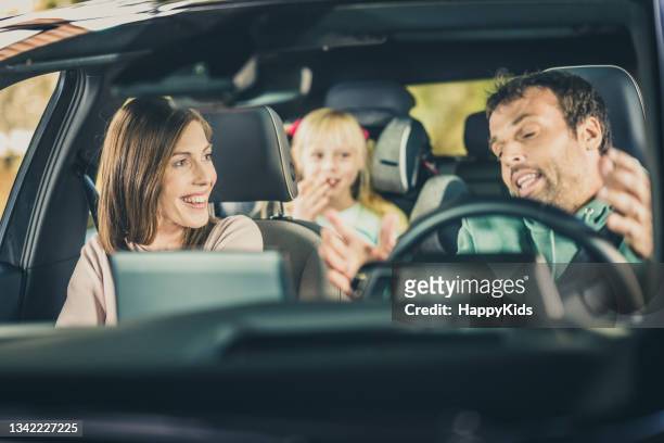 happy family enjoying in car during road trip - guy in car seat stockfoto's en -beelden