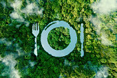 A lake in the shape of a cutlery plate, in the middle of unspoilt nature. A metaphor for veganism, vegetarianism and the meat-free trend in eating. 3d rendering.
