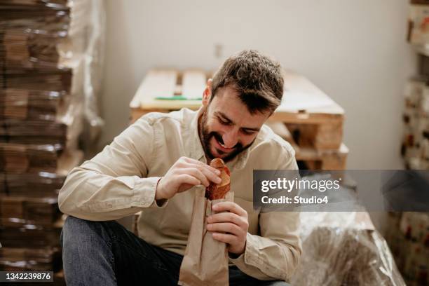 industrial laborer eating a sandwich - lunchpauze stockfoto's en -beelden